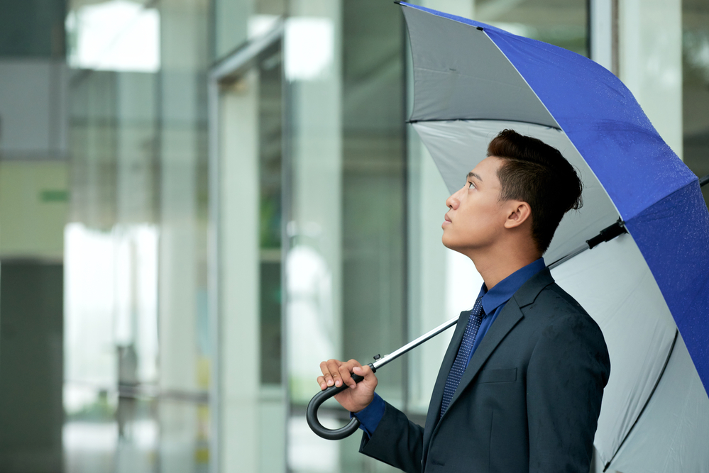 man in suit with blue umbrella