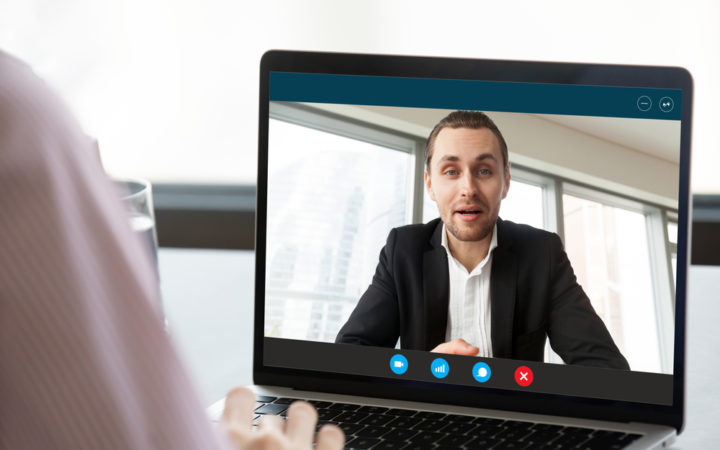 Businesswoman having distant talk with colleague through videocall screen view